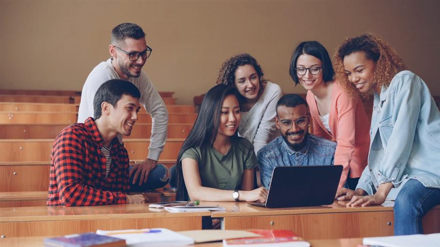 Group of students reviewing options together around a laptop